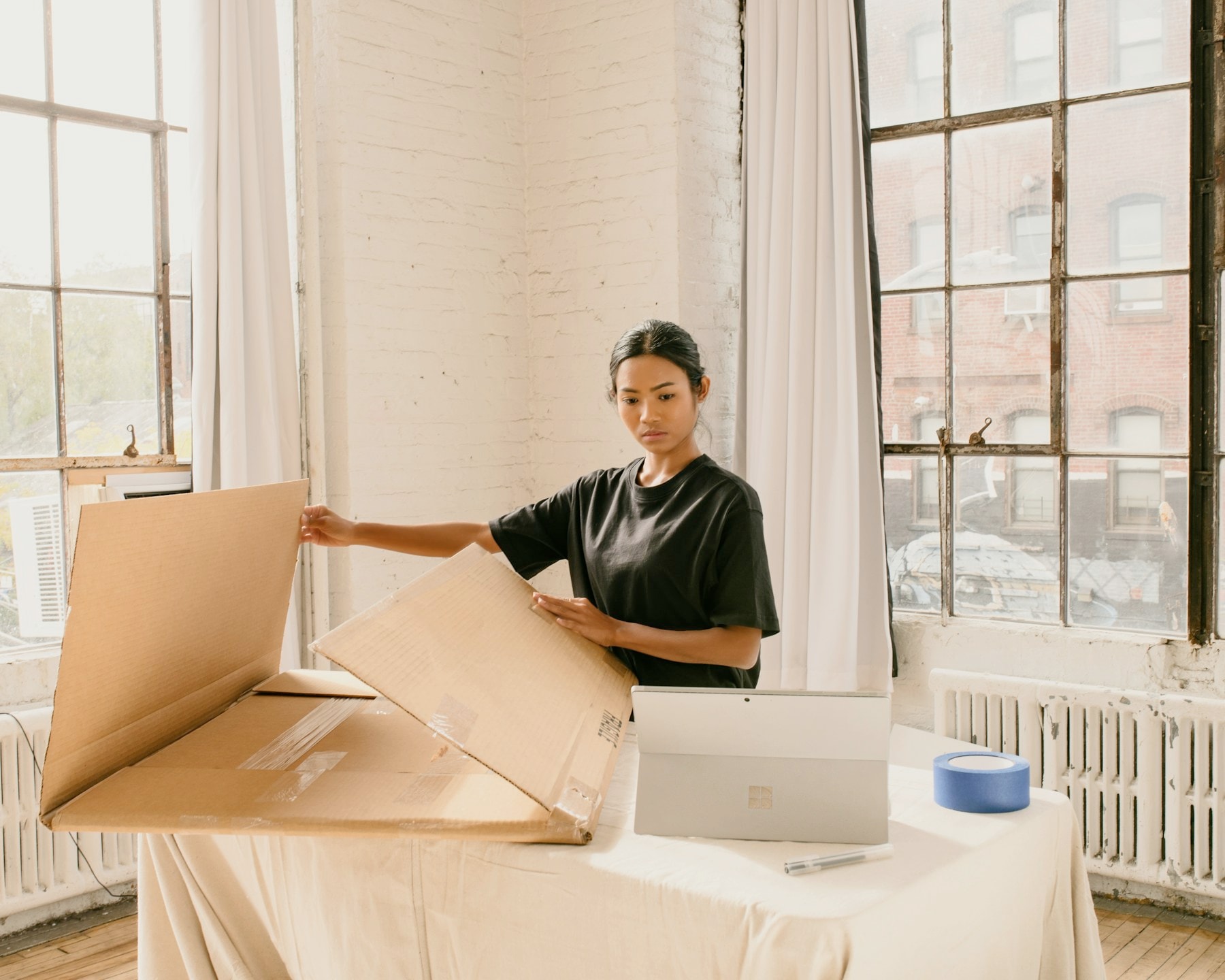 Ecommerce operator preparing shipping cartons beside a laptop
